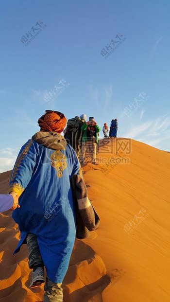 走在沙丘上的人群