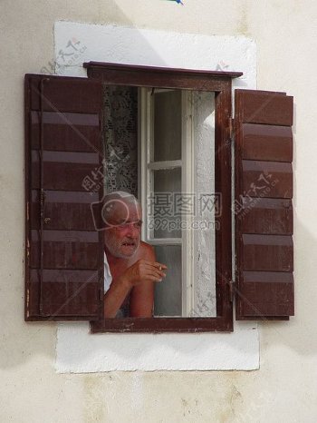从窗户眺望的老年男性