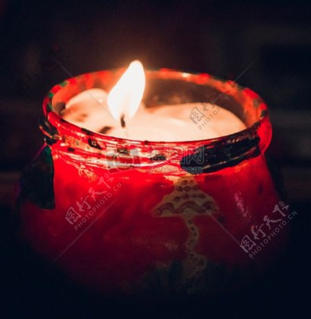 红色容器中燃烧的蜡烛
