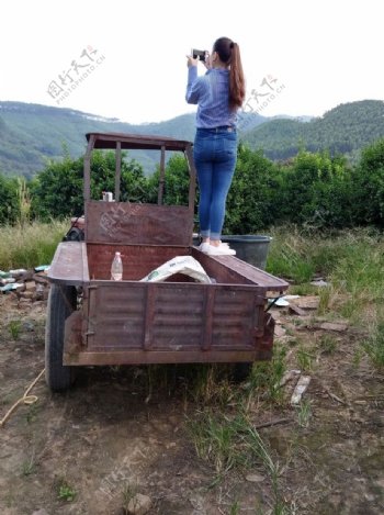 站在拖拉机上拍照的女孩