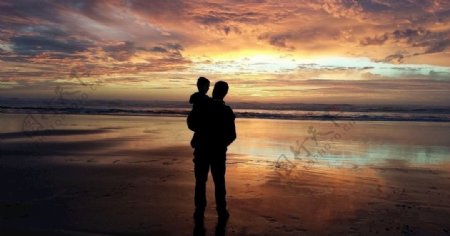 父亲与孩子在海边看日落